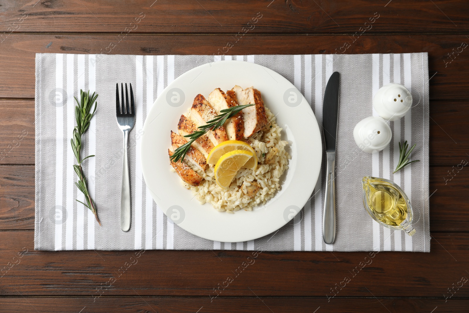 Photo of Delicious chicken risotto served on wooden table, flat lay