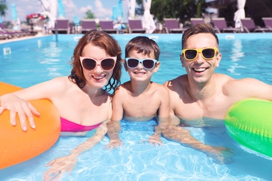 Happy family in swimming pool at resort