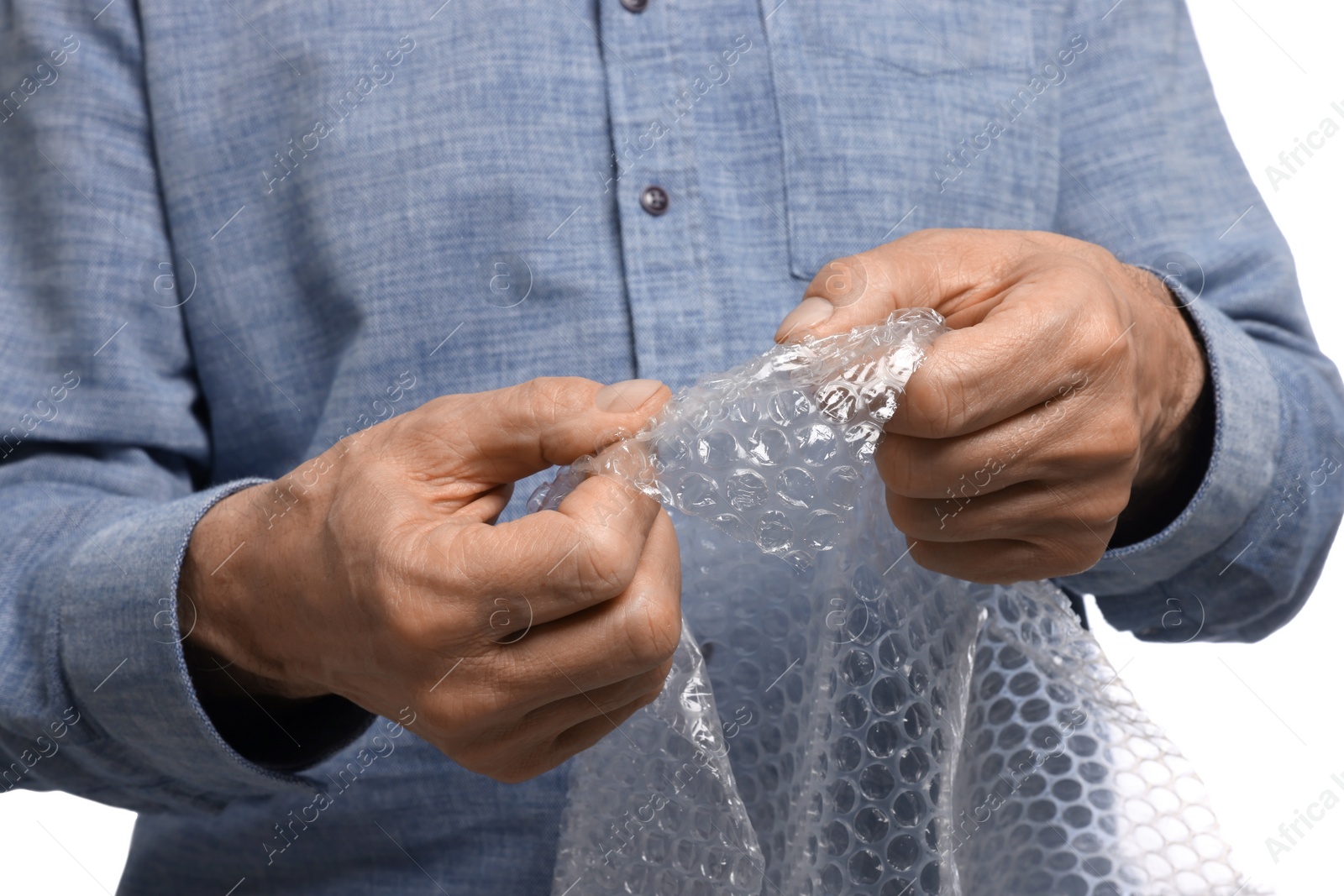 Photo of Senior man popping bubble wrap on white background, closeup. Stress relief