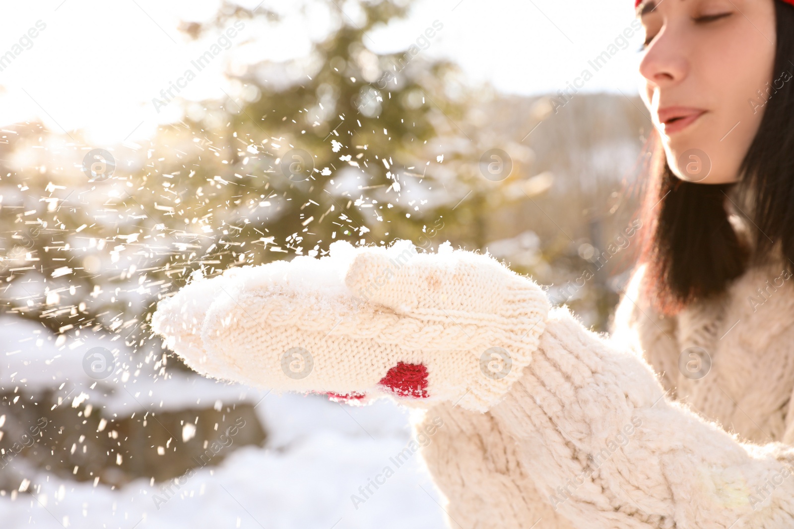 Photo of Young woman blowing snow outdoors, closeup. Winter vacation