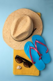 Flat lay composition with different beach accessories on light blue background