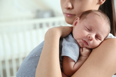 Photo of Young woman with her newborn baby at home, closeup