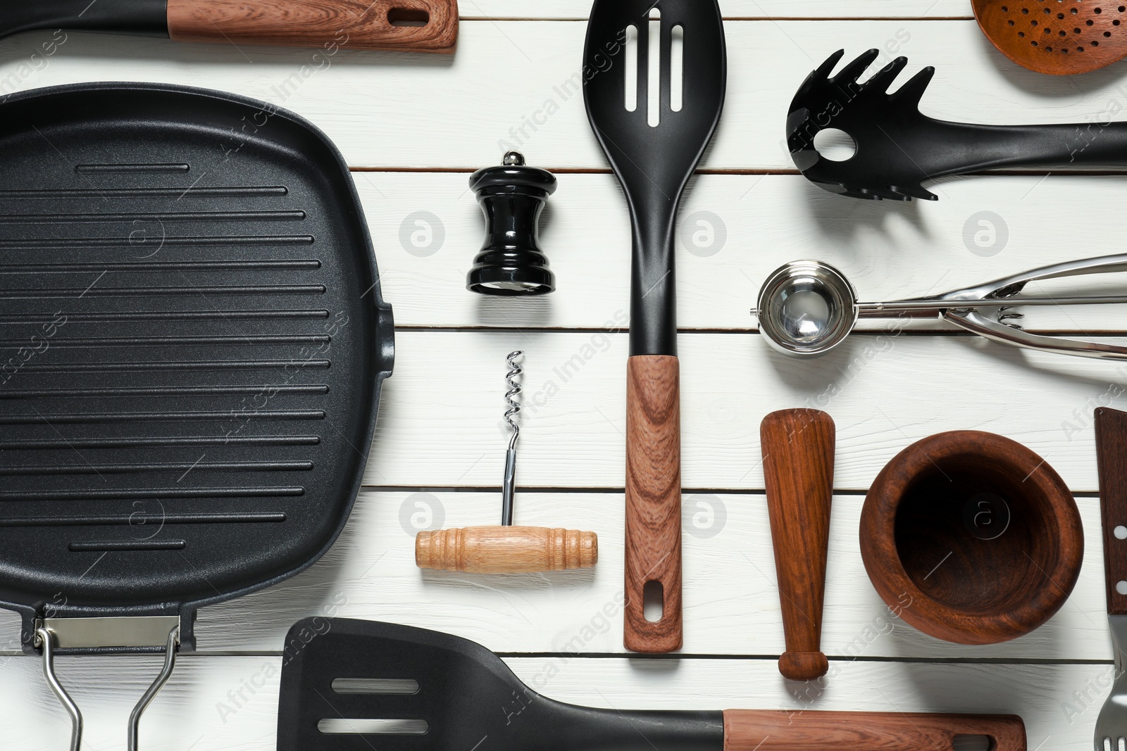 Photo of Set of different kitchen utensils on white wooden table, flat lay