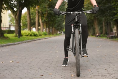 Photo of Man riding bicycle on road outdoors, closeup. Space for text