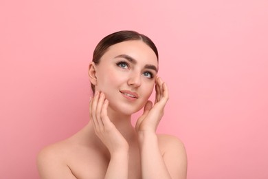 Makeup product. Woman with black eyeliner and beautiful eyebrows on pink background