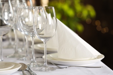 Photo of Table setting with empty glasses, plates and cutlery indoors