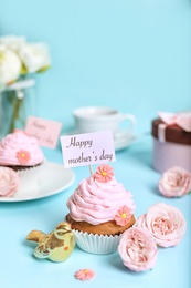 Photo of Festive surprise with tasty treat for Mother's Day on color background