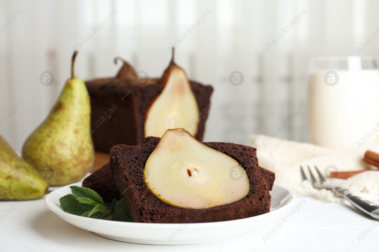 Photo of Tasty pear bread served with mint on white wooden table. Homemade cake