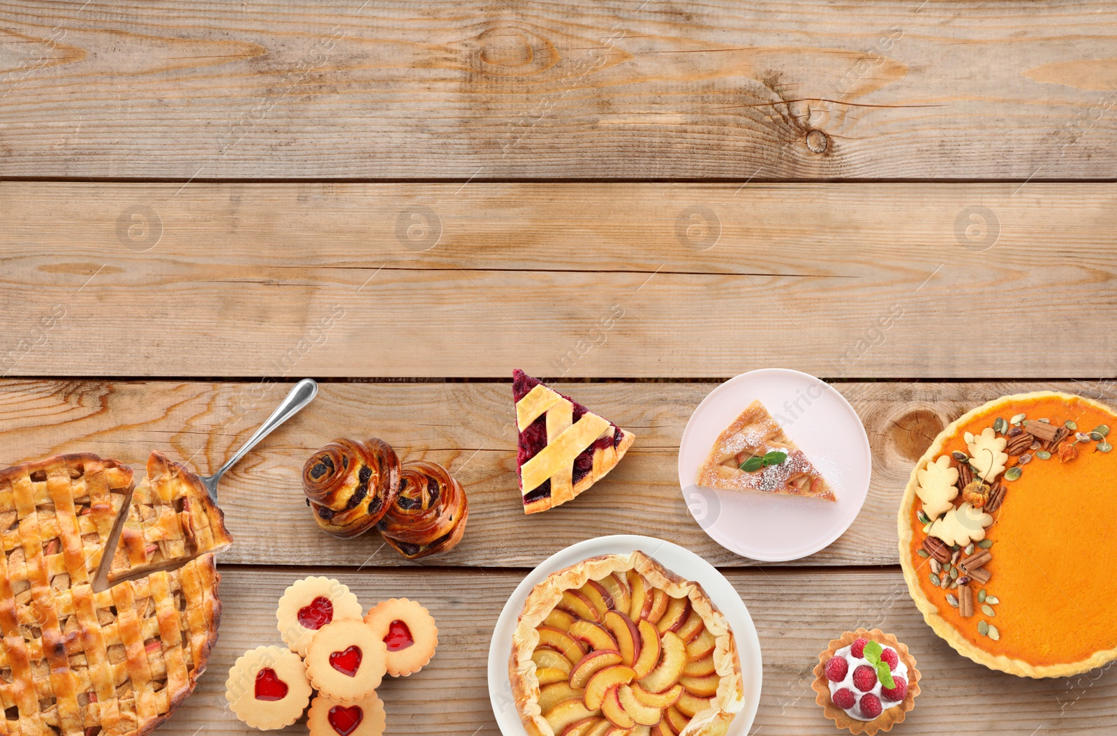 Image of Many different delicious pies on wooden table, flat lay. Space for text 