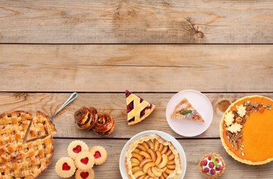 Many different delicious pies on wooden table, flat lay. Space for text 