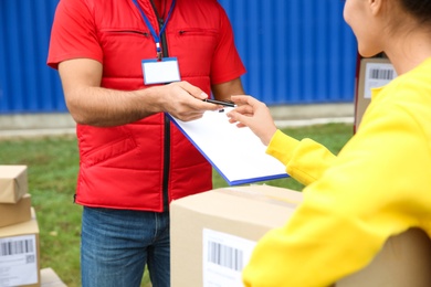 Photo of Courier receiving receipt signature from customer outdoors, closeup