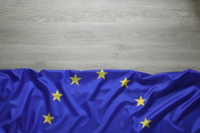 Photo of Flag of European Union on wooden background, top view. Space for text