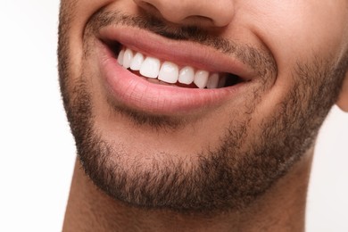 Smiling man with healthy clean teeth on white background, closeup