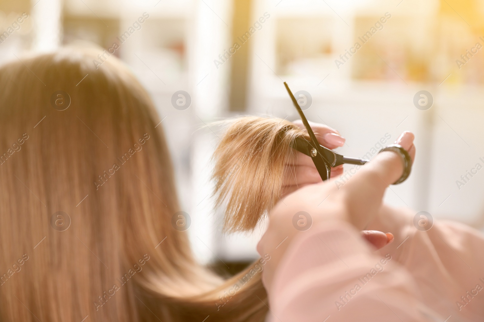 Image of Hairdresser making stylish haircut with professional scissors in salon, closeup