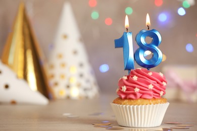 18th birthday, coming of age party. Delicious cupcake with number shaped candles on table, space for text
