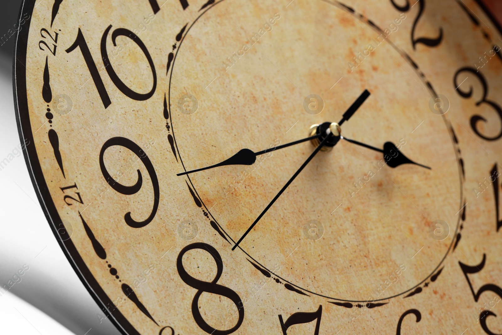 Photo of Stylish round clock on white background, closeup. Interior element