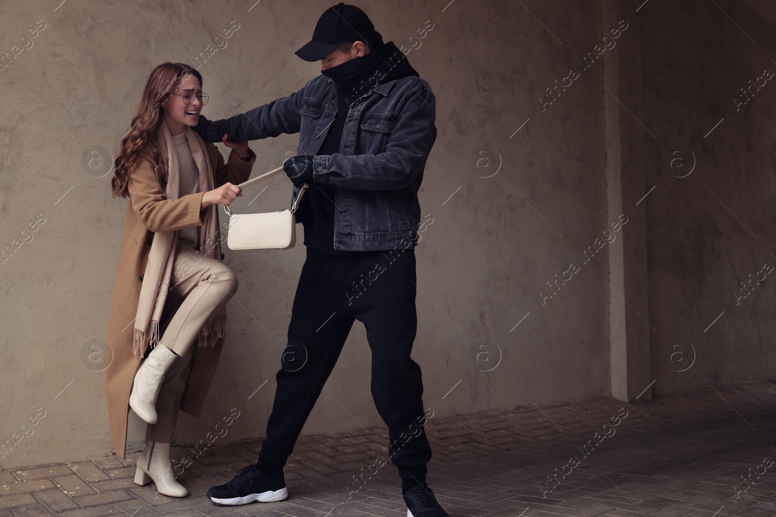 Photo of Woman fighting with thief while he trying to steal her bag outdoors, space for text. Self defense concept