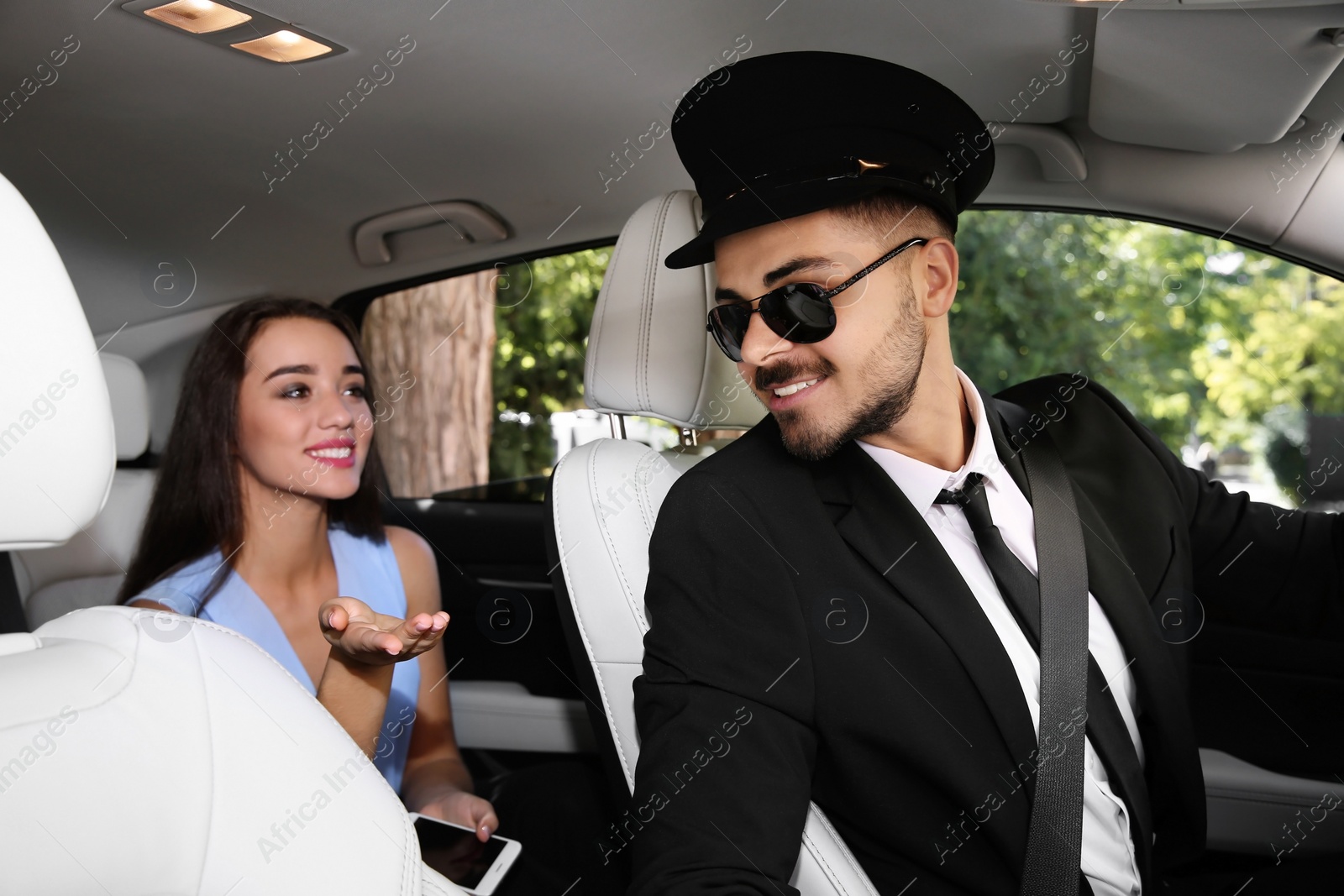 Photo of Young businesswoman talking with driver in luxury car