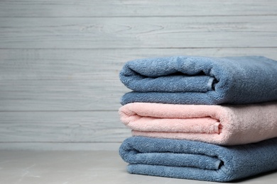 Photo of Stack of fresh towels on table. Space for text