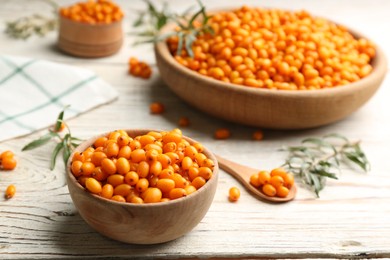 Photo of Fresh ripe sea buckthorn on white wooden table