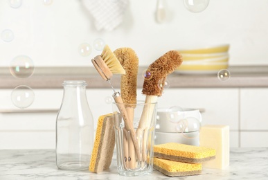 Photo of Cleaning supplies for dish washing and soap bubbles in kitchen