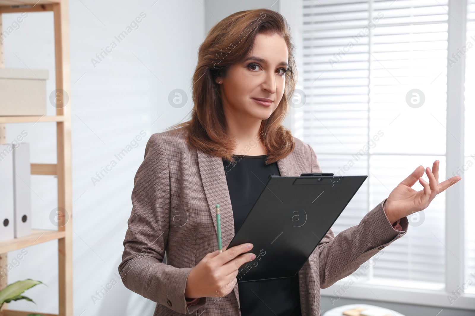 Photo of Portrait of psychotherapist with clipboard in office