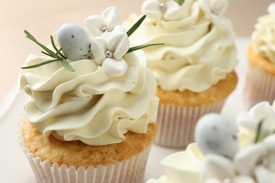 Tasty Easter cupcakes with vanilla cream on table, closeup