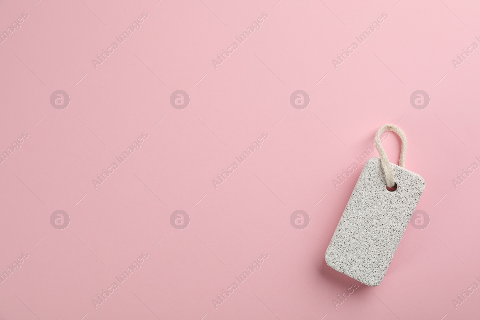 Photo of Pumice stone on pink background, top view. Space for text