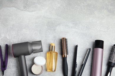 Flat lay composition with hairdressing equipment on grey stone background. Space for text