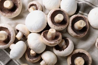 Photo of Fresh champignon mushrooms on fabric, top view