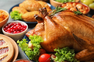 Photo of Delicious roasted turkey for traditional festive dinner on table, closeup