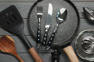 Photo of Set of kitchen utensils on dark grey wooden table, flat lay