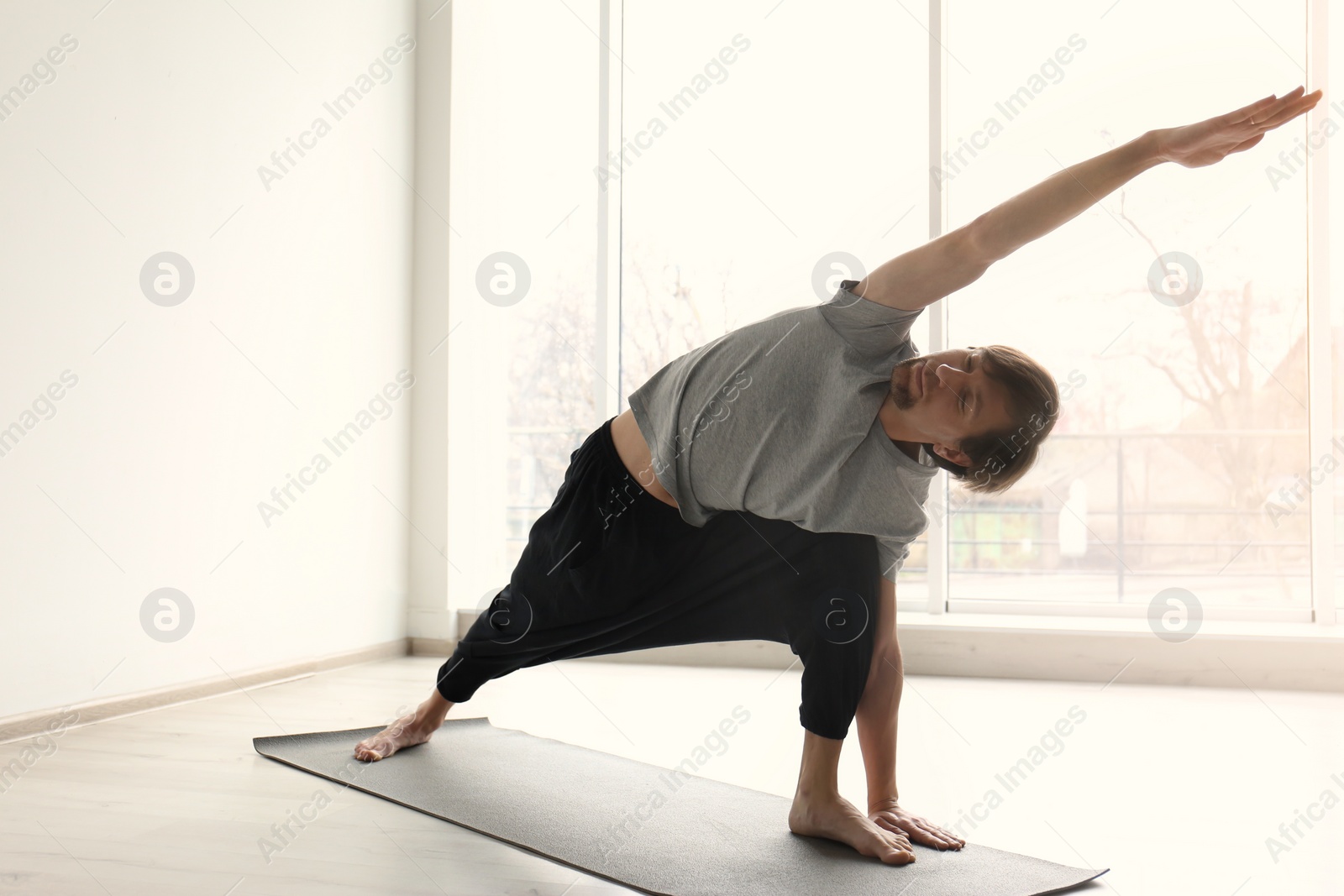 Photo of Young man practicing yoga indoors