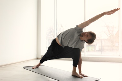 Young man practicing yoga indoors