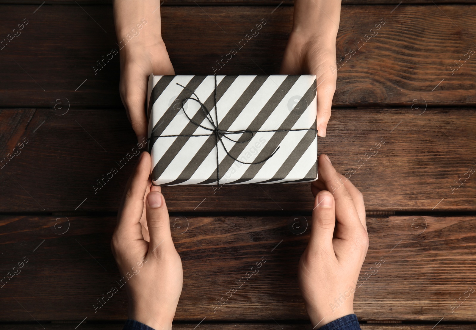 Photo of Daughter giving present to her dad over wooden table, top view. Happy father's day