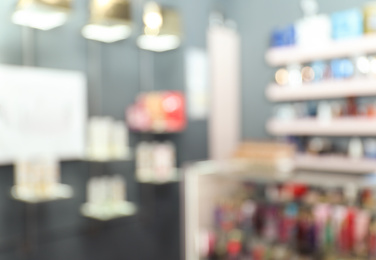 Photo of Blurred view of counter and shelves with perfume bottles in shop