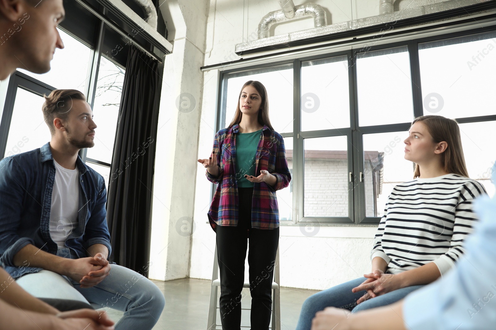 Photo of Psychotherapist working with patients in group therapy session indoors, low angle view