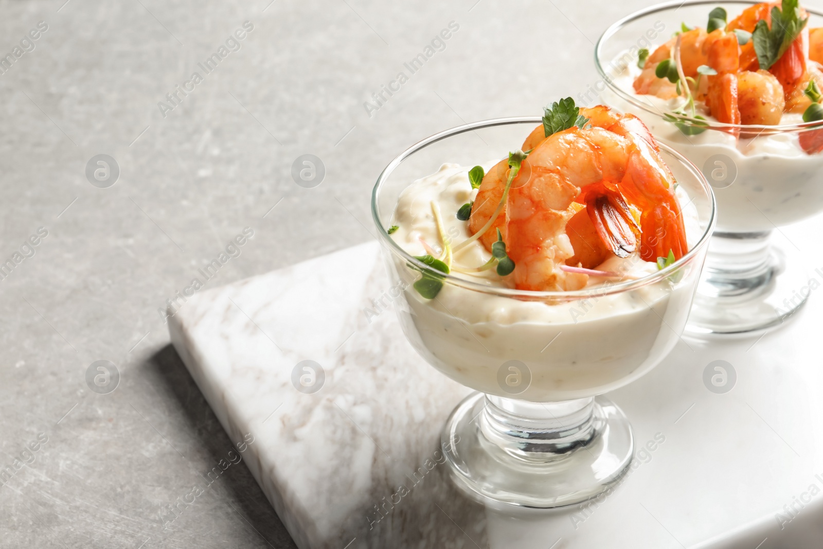 Photo of Bowls with fried shrimps and sauce on marble board