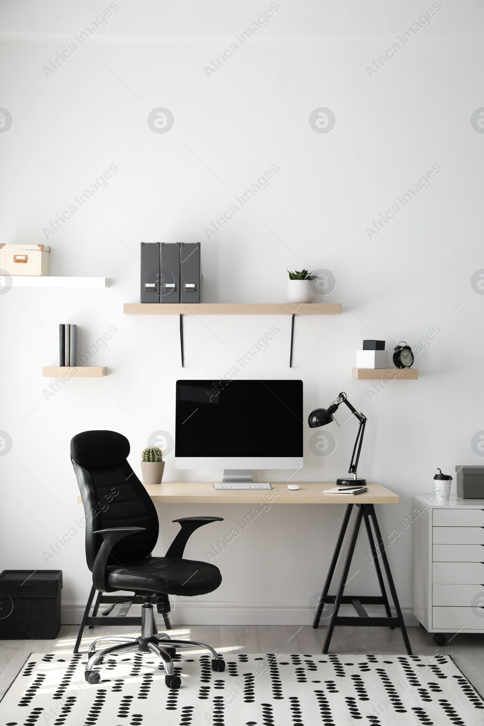 Photo of Comfortable office chair near table with modern computer