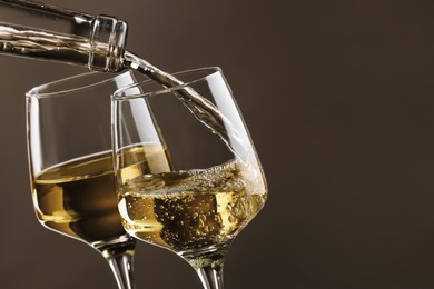 Photo of Pouring tasty aromatic wine in glass on gray background, closeup. Space for text