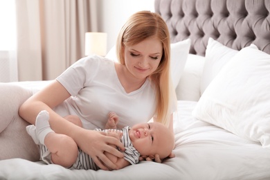 Photo of Mother with her baby resting on bed at home