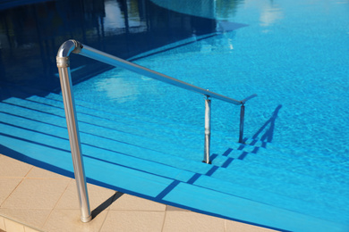 Photo of Outdoor swimming pool with clear water on sunny day. Summer vacation