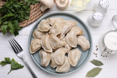 Photo of Delicious dumplings (varenyky) with potatoes served on white wooden table, flat lay