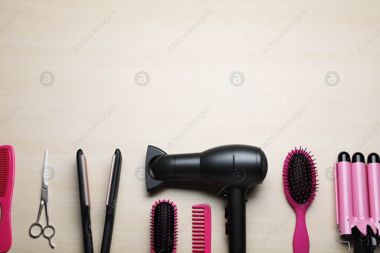 Photo of Flat lay composition of professional hairdresser tools on beige table, space for text