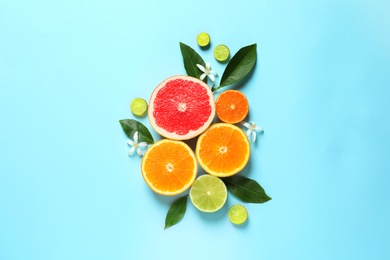 Flat lay composition with citrus fruits, leaves and flowers on color background