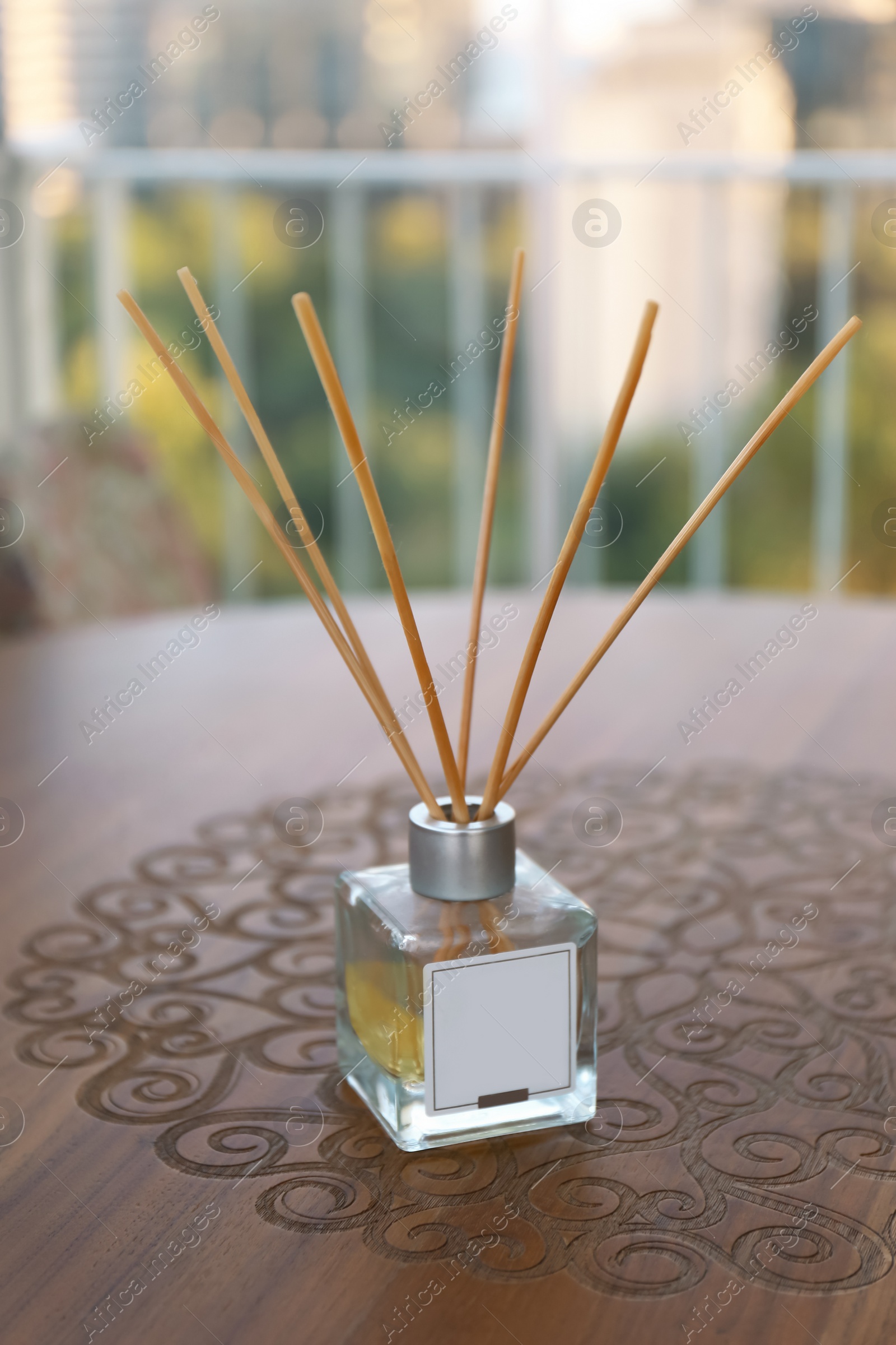 Photo of Reed air freshener on wooden table in room