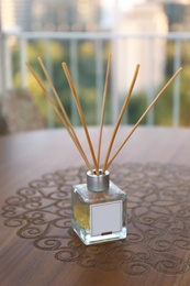 Photo of Reed air freshener on wooden table in room