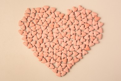 Heart made of vitamins for pets on beige background, top view