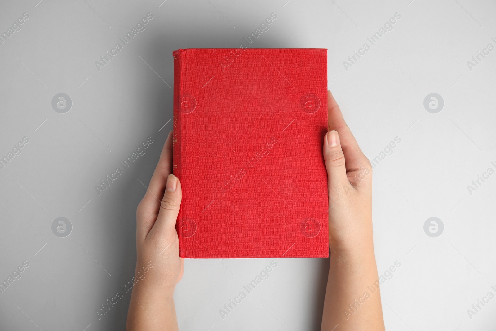 Photo of Woman with book on light grey background, top view. Space for design