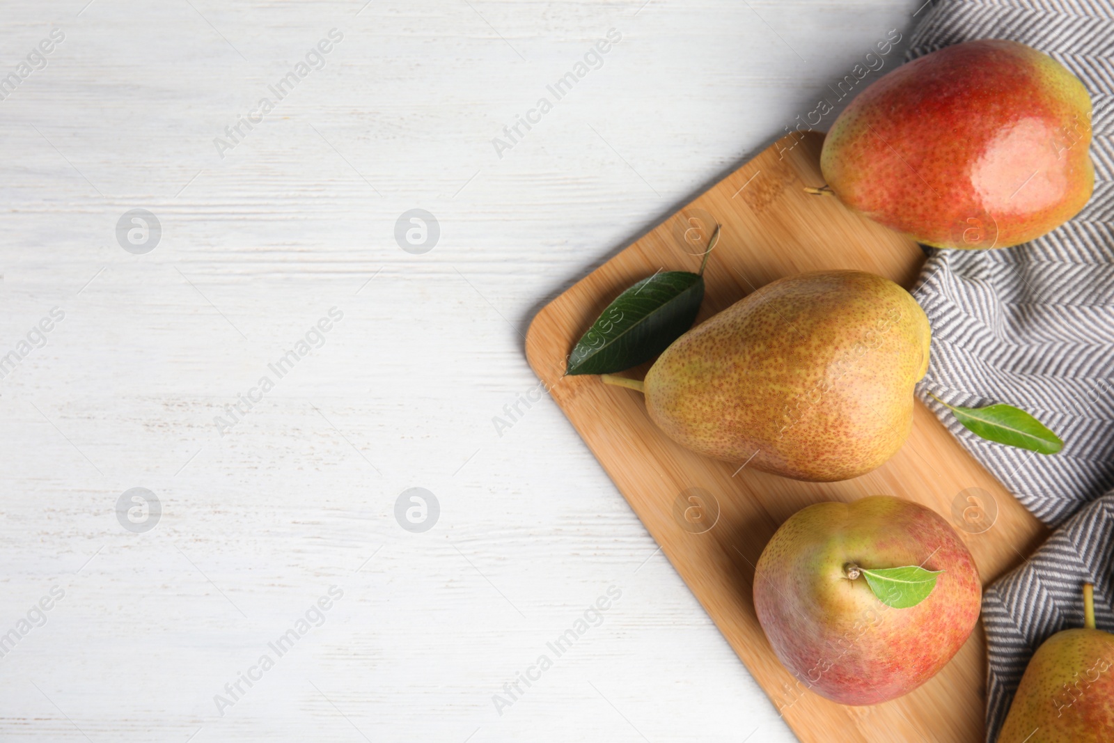 Photo of Ripe juicy pears on white wooden table, top view. Space for text